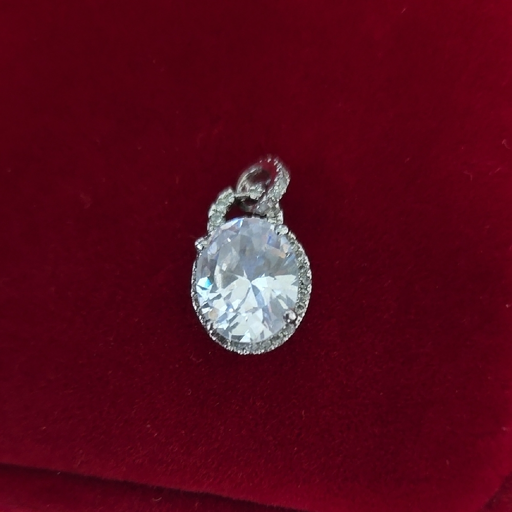 Elegant Silver Oval Pendant With Halo and Small Stones On Bale.